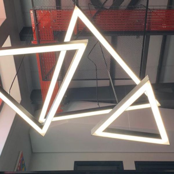 odern triangle LED pendant lighting system in a private office and public commercial area